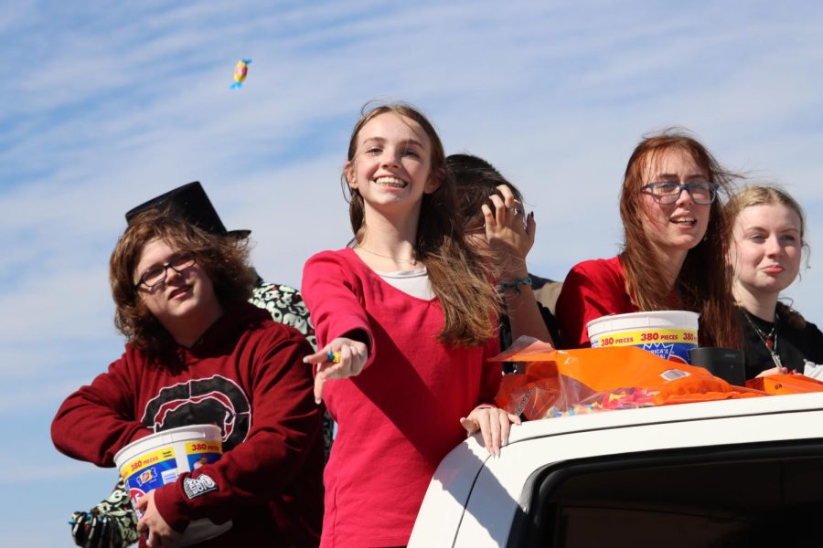Throwing pieces of dubble bubble, senior Natalie Partridge rides in the OneMaize Media truck. ¨My favorite part about the parade was getting to see how excited all the little kids were and getting to throw them candy,¨ said Partridge. 