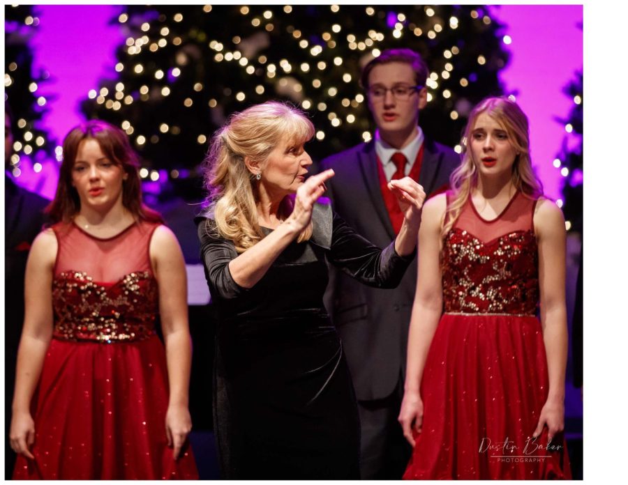 Doris Prater directs the choir as they surround the auditorium for the final song of their recent holiday concert.