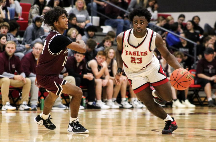 Senior Tayveon Williams dribbles the ball on a fast break towards the basket. The final score of the game was 52-50 and the Eagles won their first game of the year to start 1-0.