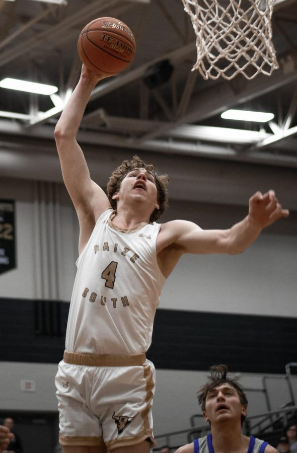 Junior Tory Homan slams down a dunk over a Goddard defender. Maize South defeated the Goddard Lions on Tuesday night and increased their record to 10-2 with a 63-30 win.
