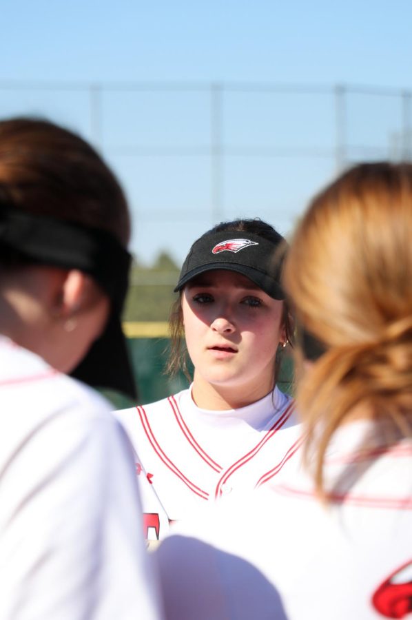 Freshman first baseman Grace Swart listens as Coach Jeff Topping discusses the previous inning with the team. The Eagles are 1-2 so far this season. 
