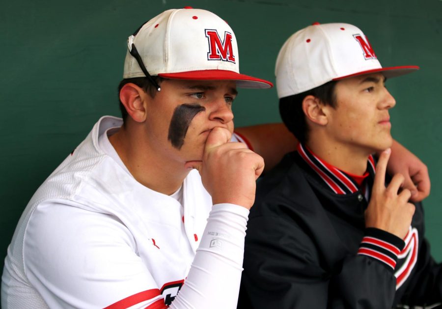 Juniors Davin Hinote and Cole Chalistari watch the first game from the dugout as the Eagles lose 4-6.