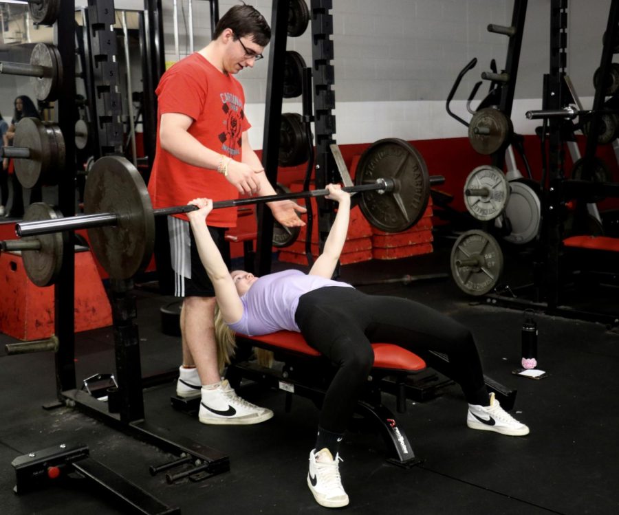 Sophomore AJ Bensing spots Beth Whitney as she pushes for a new personal record in powerlifting.