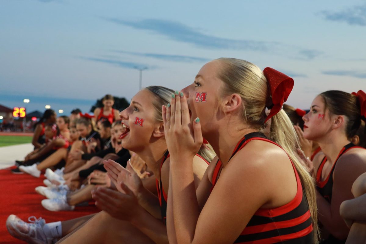 Seniors Gentry Nittler and Tristin Combs scream towards to field to show their supports for the middle school cheer team. 