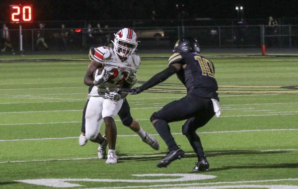 Junior Shannon Jones tries to escape the maverick defense so he can continue down the field with the ball.